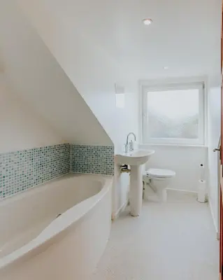 a white bathroom with a tub and a sink at Stag's View Lodge in Edinburgh
