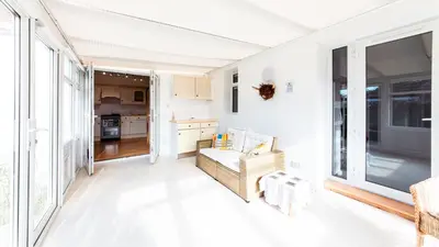 a living room with white walls and a large window at Stag's View Lodge in Edinburgh