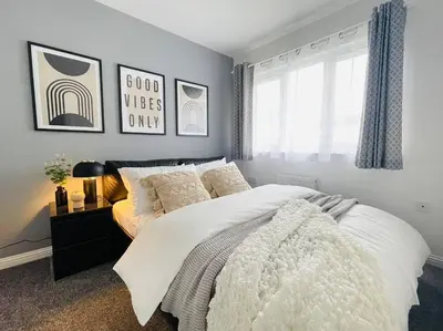 a bedroom with a large white bed with a window at Elegant 3BR house in Glasgow in Garthamlock