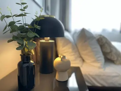 a table with a lamp and a vase with a plant at Elegant 3BR house in Glasgow in Garthamlock