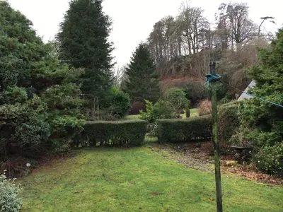 a garden with a pole in the grass at Smithy House in Crinan