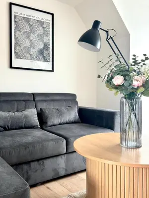 a living room with a couch and a table with flowers at Almondvale Apartment in Livingston
