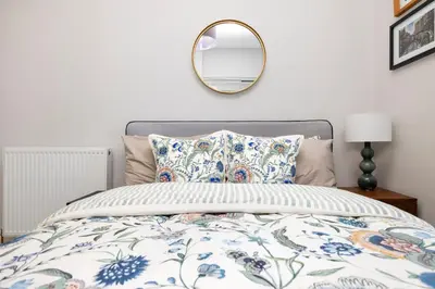 a bedroom with a bed with a mirror and pillows at Edinburgh Stockbridge Charm Apartment in Edinburgh