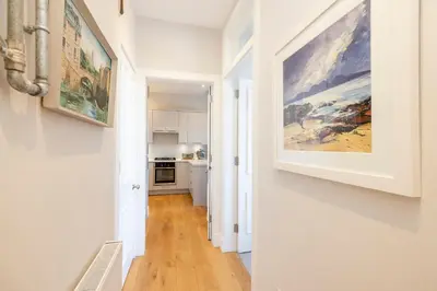 a hallway with a painting hanging on a wall at Edinburgh Stockbridge Charm Apartment in Edinburgh