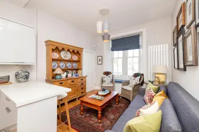 a living room with a couch and a table at Edinburgh Stockbridge Charm Apartment in Edinburgh
