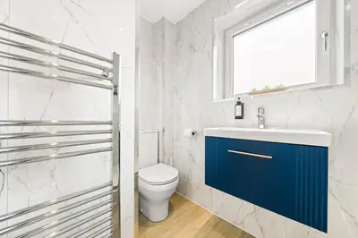 a bathroom with a toilet and a sink and a window at Bright & Modern 3-Bed House Next To Glasgow Airport in Abbotsinch