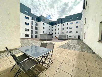 a patio with a table and chairs in front of a building at The Clyde Retreat, 2 Bedrooms in Glasgow