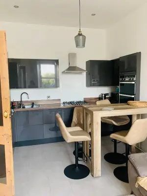 a kitchen with a wooden table and some chairs at Rachael's House in Moffat