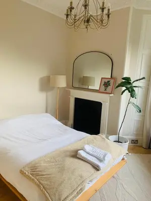 a bedroom with a bed with a mirror on the wall at Rachael's House in Moffat
