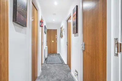 a corridor of a hallway with wooden doors and a hallwayngth at Super Prime The City Residence in Dunfermline