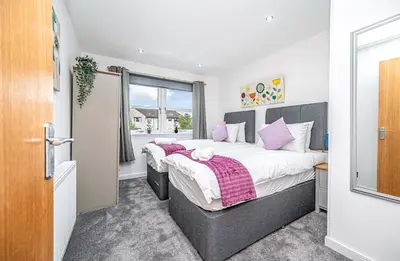 a bedroom with a large bed with pink pillows at Super Prime The City Residence in Dunfermline