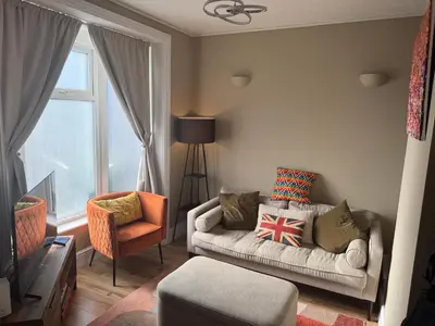 a living room with a couch and a chair at Southsea Home with Free Parking in Moffat