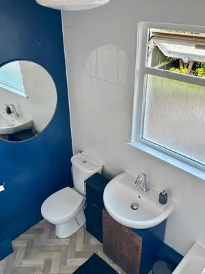 a blue and white bathroom with a toilet and a sink at Southsea Home with Free Parking in Moffat
