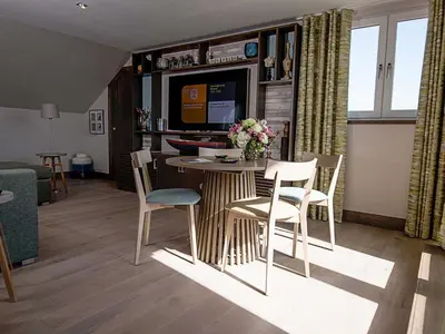 a living room with a dining table and chairs at The Waterside Hotel & Spa in Seamill