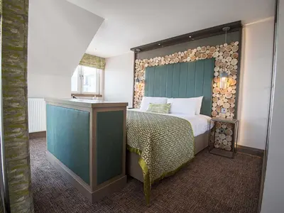 a bedroom with a bed with a wooden headboard at The Waterside Hotel & Spa in Seamill
