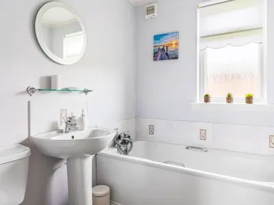 a white bathroom with a sink and a tub and a mirror at Chalet Loch Side Lodge 5 by Interhome in Kinross