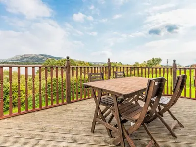 a wooden table and chairs on a wooden deck at Chalet Loch Side Lodge 5 by Interhome in Kinross