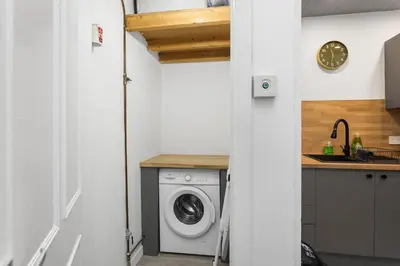 a kitchen with a washing machine and a sink at Sleek Canalside Stay in Edinburgh in Edinburgh