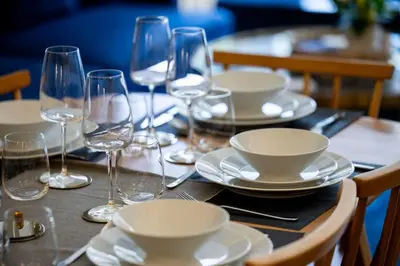 a table with plates and wine glasses on it at The Burnbank Experience in Glasgow