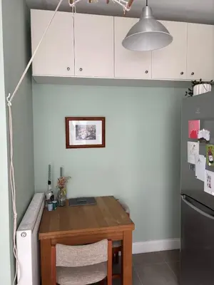 a kitchen with a wooden table and a refrigerator at Modern One Bed Flat, Historic Old Town Edinburgh in Edinburgh