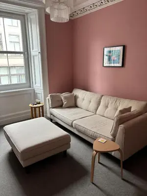 a living room with a couch and a table at Modern One Bed Flat, Historic Old Town Edinburgh in Edinburgh