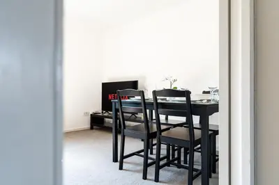 a black dining room table with black chairs in a room at 2 Bedroom Flat - Free Parking- by Holiday Homes in Clydebank