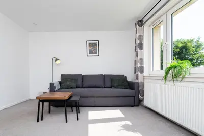 a living room with a couch and a table at 2 Bedroom Flat - Free Parking- by Holiday Homes in Clydebank
