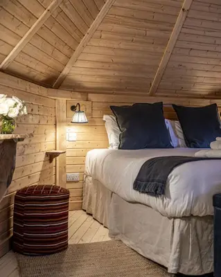 a bedroom with a bed in a wooden cabin at Carnethy Cabin in Kirknewton