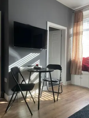 a dining room with two chairs and a table and a television at Foundry Street Apartment 1 - Dunfermline City Centre in Dunfermline