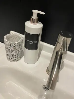 a bathroom sink with a bottle of hand wash on it at Foundry Street Apartment 1 - Dunfermline City Centre in Dunfermline