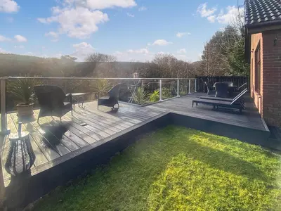 a wooden deck with a table and chairs on it at Riverside Cottage in Lamlash