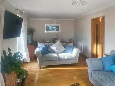 a living room with a couch and blue pillows at Riverside Cottage in Lamlash