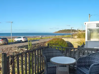 a patio with chairs and a table and the ocean at Bay View in Maidens