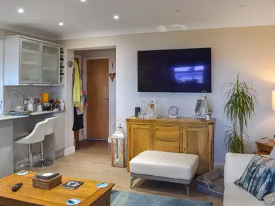 a living room with a couch and a tv on the wall at Bay View in Maidens