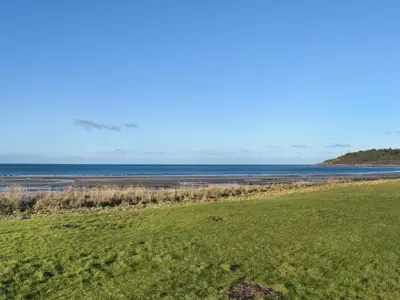 a green field with the ocean in the background at Bay View in Maidens