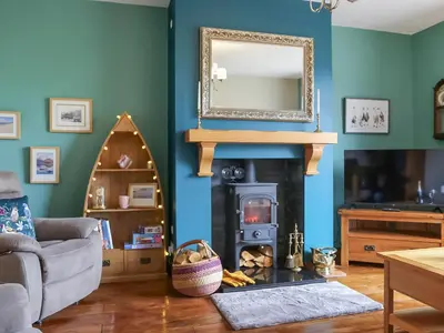 a living room with a fireplace and a mirror at Bendhu in Mill of Fortune