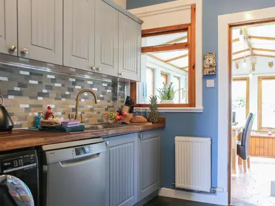 a kitchen with white cabinets and a sink at Bendhu in Mill of Fortune