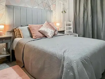 a bedroom with a large bed with pillows on it at Homely Base in Crossgates