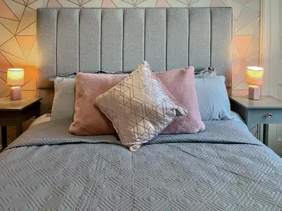 a bedroom with a bed with pillows on it at Homely Base in Crossgates