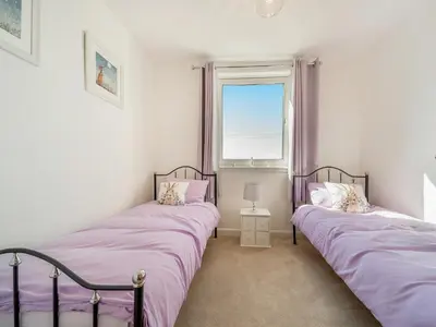 two twin beds in a room with a window at Hydee House in Dumfries