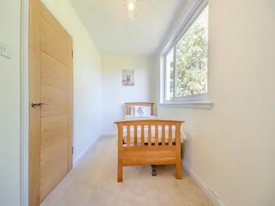 a hallway with a wooden door and a window at Hydee House in Dumfries
