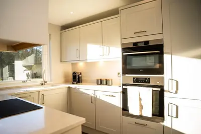 a kitchen with white cabinets and an oven at 28 Guthrie Court - Gleneagles Village