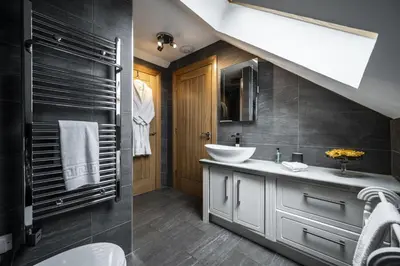 a bathroom with a sink and a toilet and a staircase at The Keep in Kirknewton