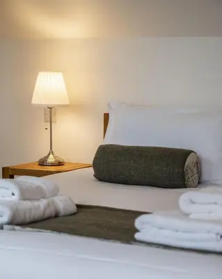 a bedroom with a bed with towels on it at The Keep in Kirknewton