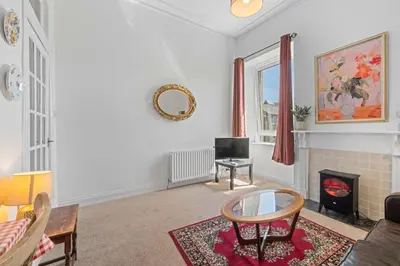a living room with a couch and a fire place at Cosy 1 Bedroom Apartment next to Fountain Park - Edinburgh in Edinburgh