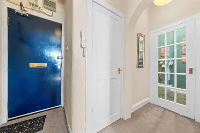 a hallway with a blue door and windows at Cosy 1 Bedroom Apartment next to Fountain Park - Edinburgh in Edinburgh