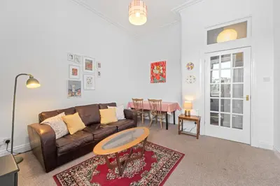 a living room with a couch and a table at Cosy 1 Bedroom Apartment next to Fountain Park - Edinburgh in Edinburgh