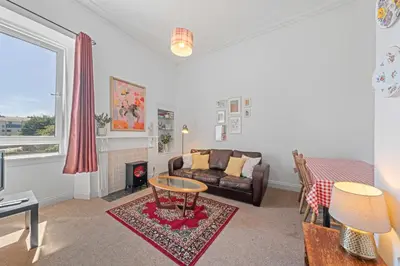 a living room with a couch and a fireplace at Cosy 1 Bedroom Apartment next to Fountain Park - Edinburgh in Edinburgh