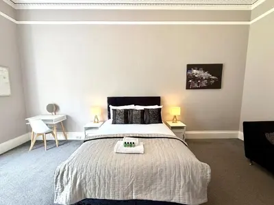 a bedroom with a large bed and two tables at New Town luxury 1 bed apartment in Edinburgh