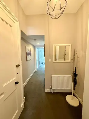 a hallway with a room with a mirror and a lamp at New Town luxury 1 bed apartment in Edinburgh